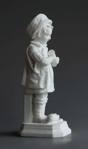 A Parian figure of a child feeding their pet cat and kittens